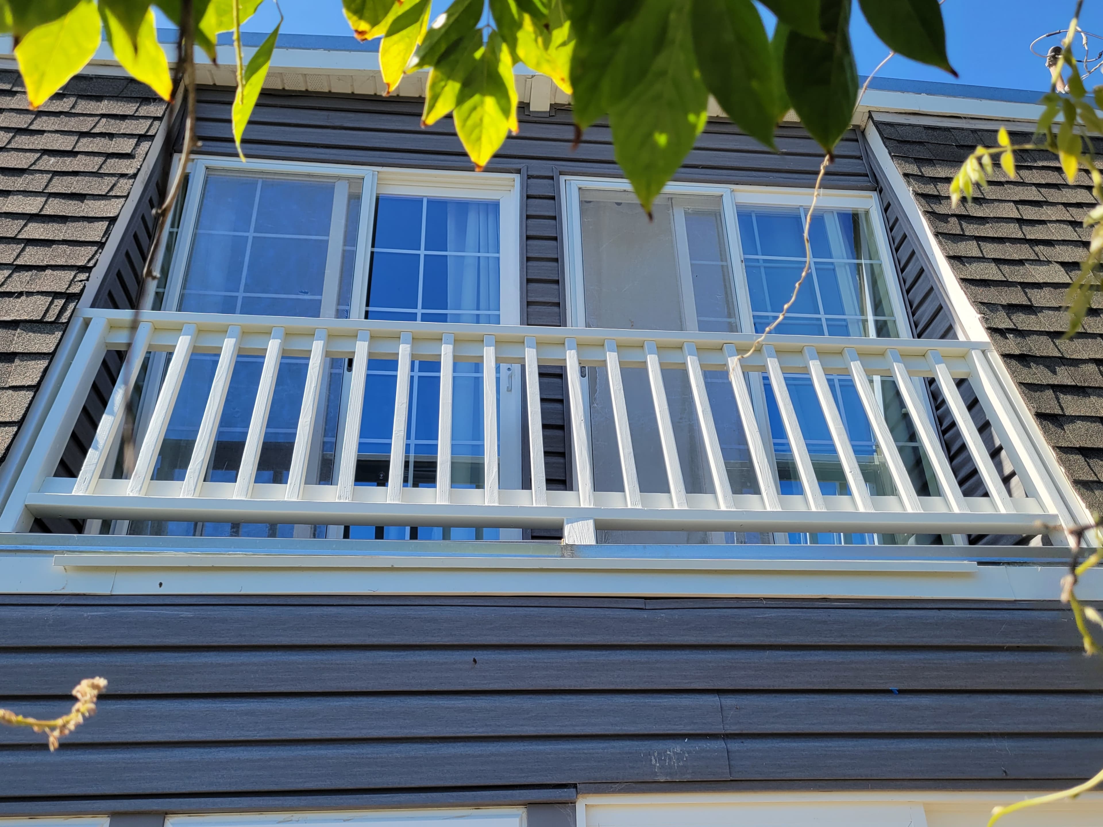 Balcony with a white fence and two patio doors